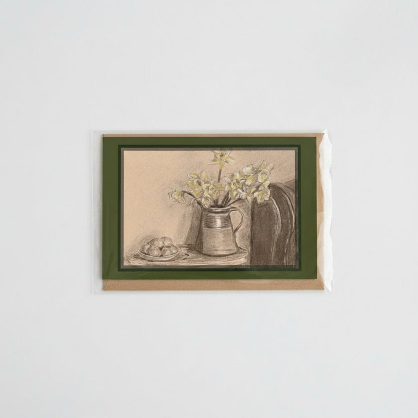 A card featuring a monochrome still life sketch of flowers and eggs, mounted on a brown kraft envelope against a light gray background.