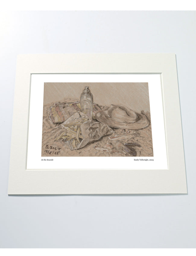a mounted art print of a drawing of a beach scene with hat, water bottle towel and chips