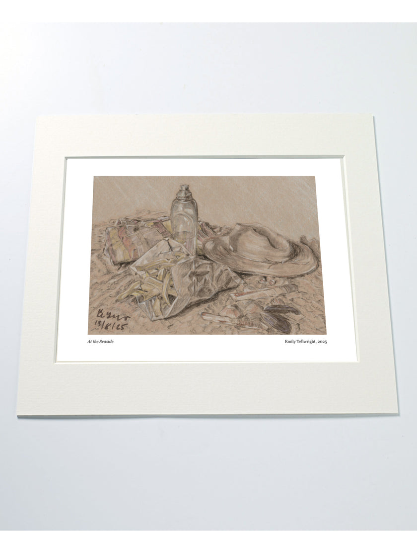 a mounted art print of a drawing of a beach scene with hat, water bottle towel and chips