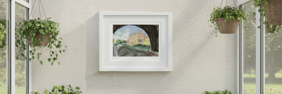 A framed print of a drawing of biddulph grange garden on a cream wall with windows either side and plants hanging