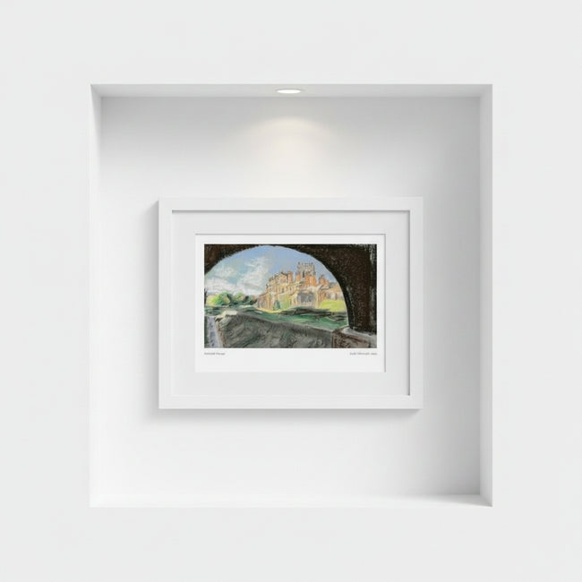 A framed art print depicting Biddulph Grange seen through a dark archway, displayed in a white frame on a white wall within a recessed niche.