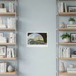 An art print of Biddulph Grange on a blue wall between book cases