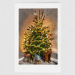 A framed art print featuring a painted Christmas tree decorated with ornaments, set against a neutral grey background.