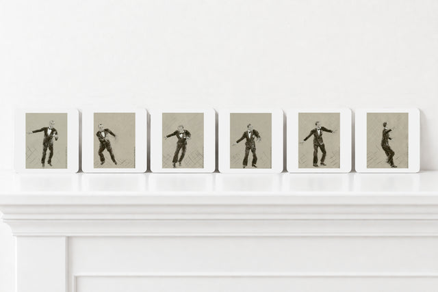 Six art print coasters arranged in a row on a white mantelpiece against a white wall. Each print shows a black-and-sepia figure posed dynamically against a muted grey background.