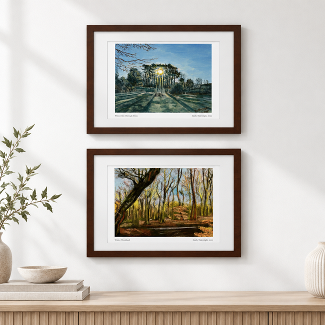 Two landscape framed prints displayed artistically on a white wall
