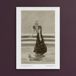 A framed monochrome art print featuring a sketch of a woman in a long dress, centered against a dark plum background.