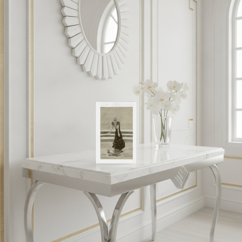 An art greetings card showing a black and white drawing of Ginger Rogers, styled on a white marble console table with white orchids in a vase and a sunburst mirror on the wall behind it.