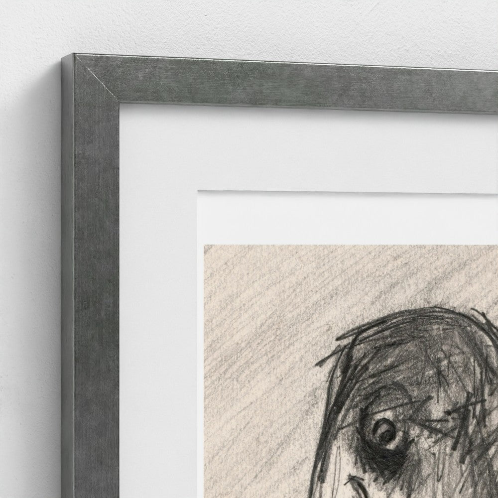 Close-up of a framed art print showing a textured gray frame, white mat board, and a charcoal sketch on beige paper against a white wall.