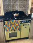 Harlequin Teatowel hanging on a green range cooker