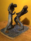 Ceramic sculpture of two air guitarists duelling.