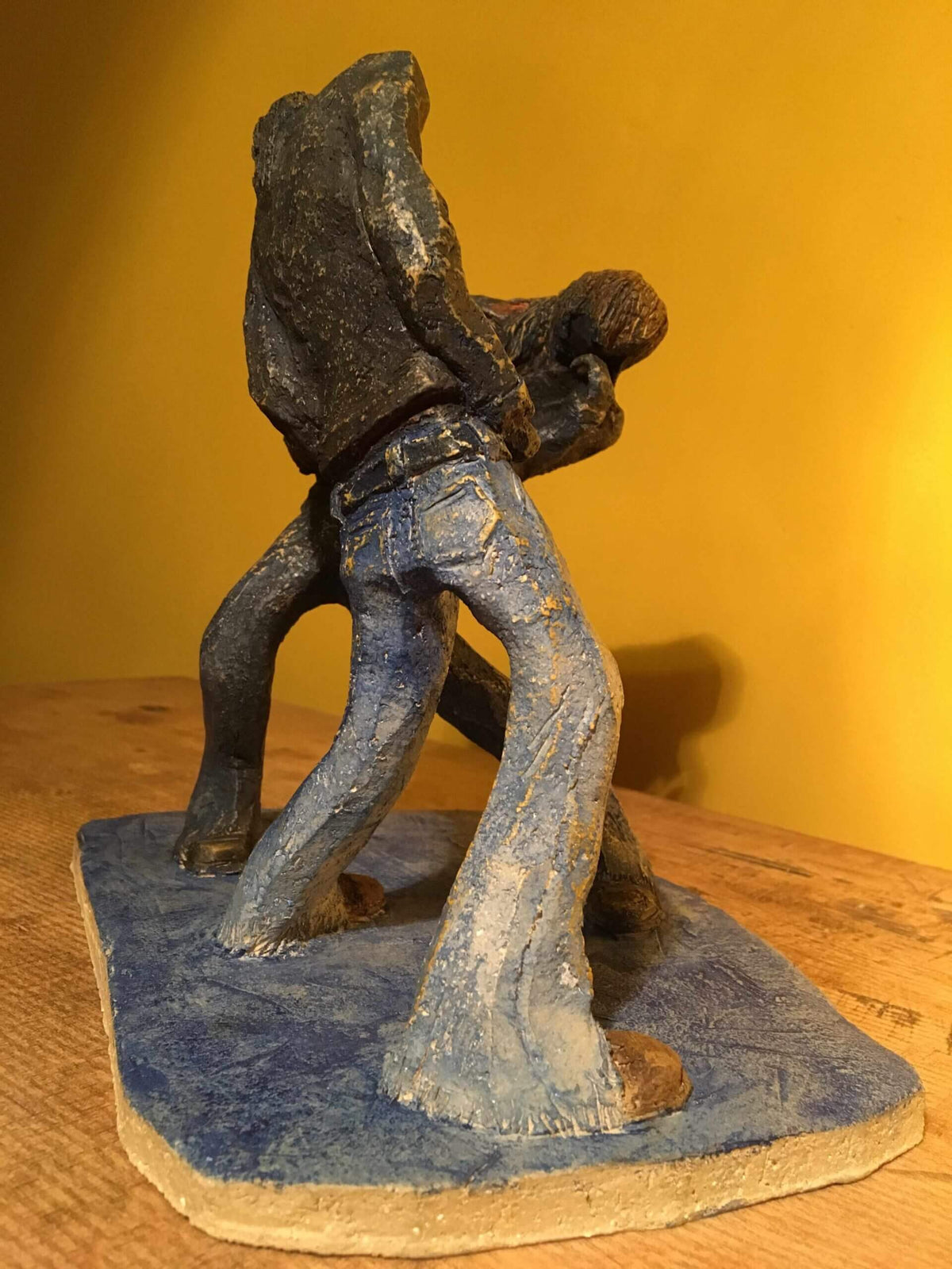 Ceramic sculpture of two air guitarists duelling.