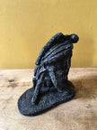 Ceramic sculpture of a rock guitarist painted black.