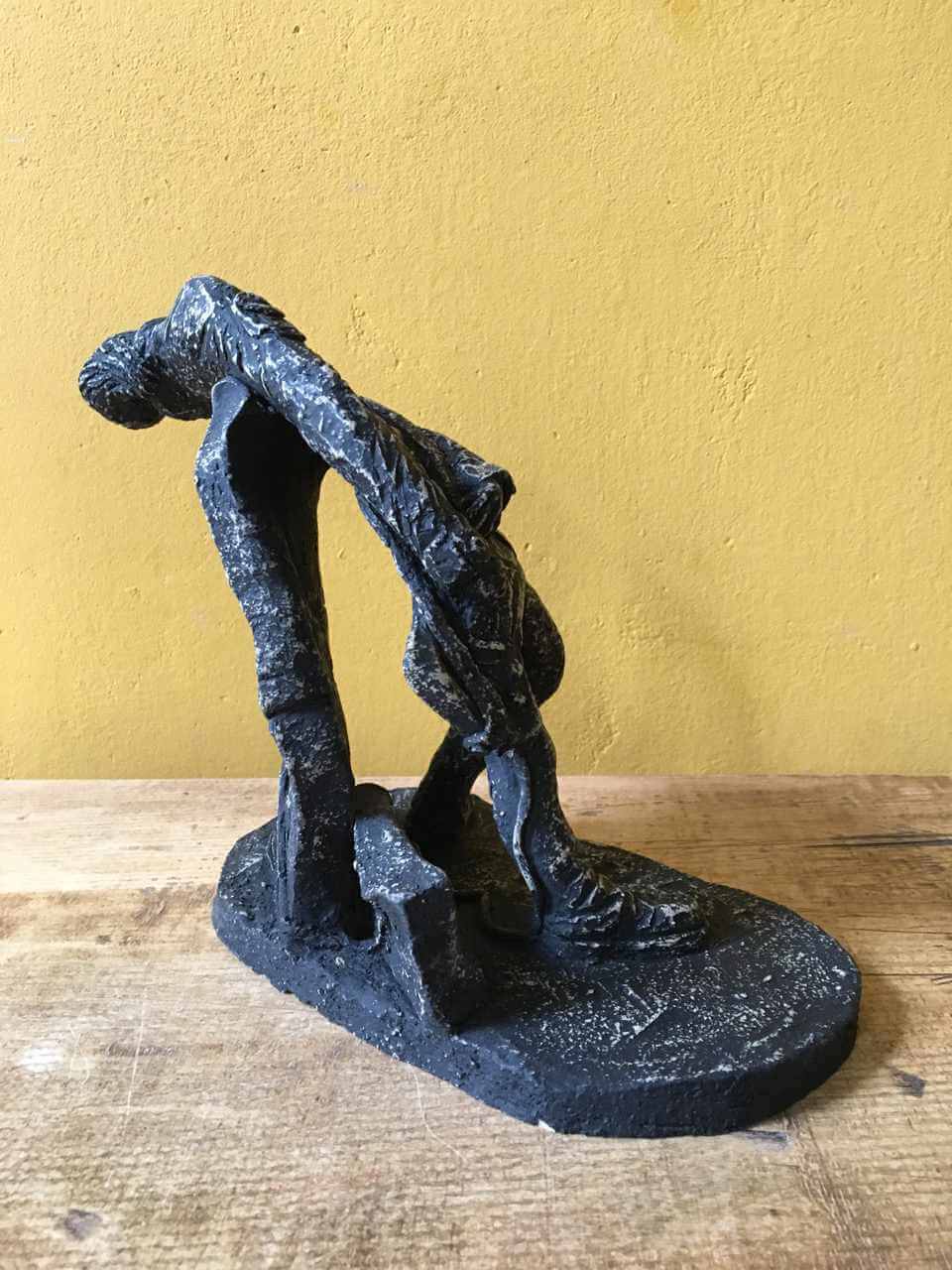Ceramic sculpture of a rock guitarist painted black.