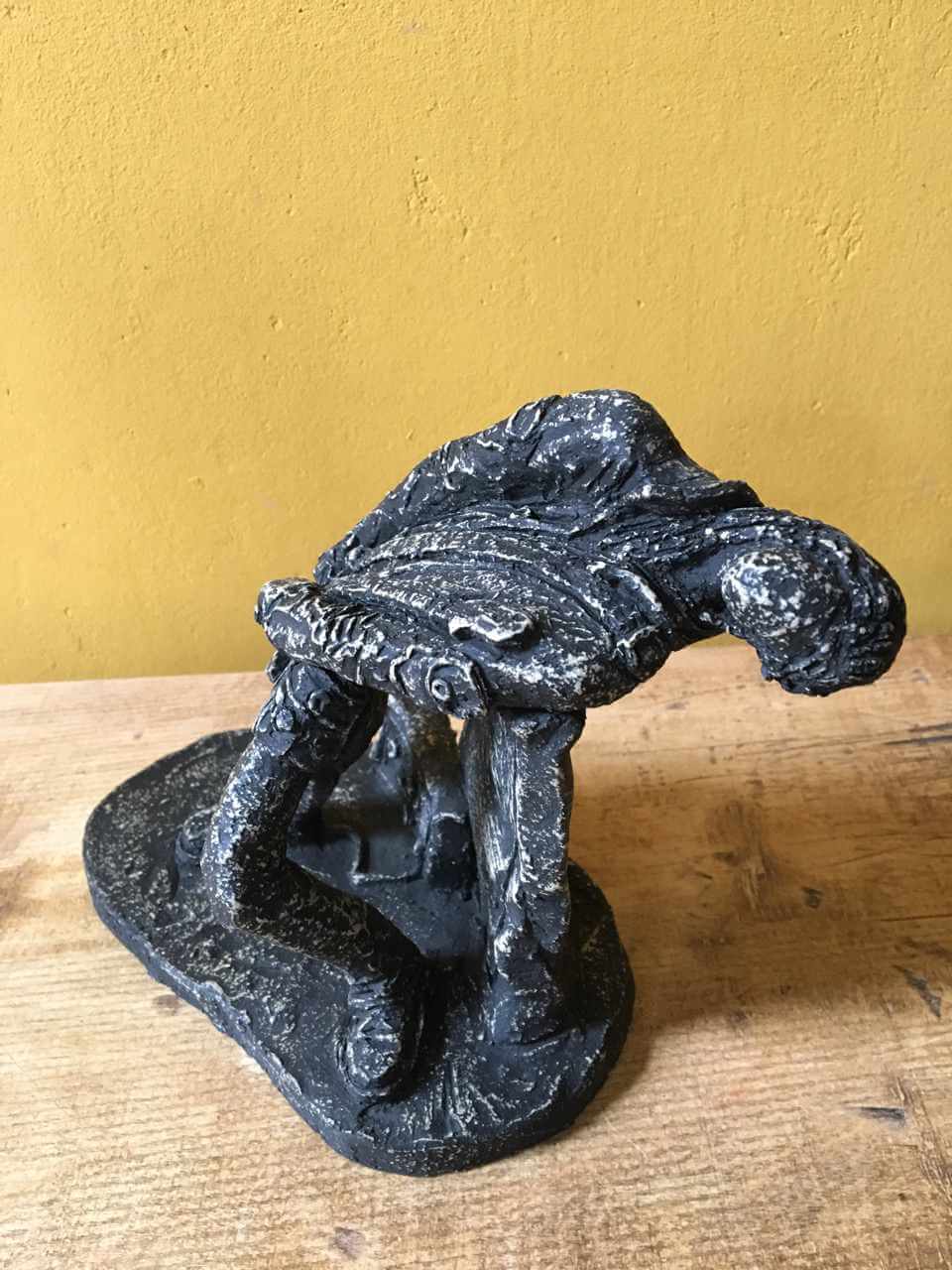 Ceramic sculpture of a rock guitarist painted black.