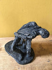 Ceramic sculpture of a rock guitarist painted black.