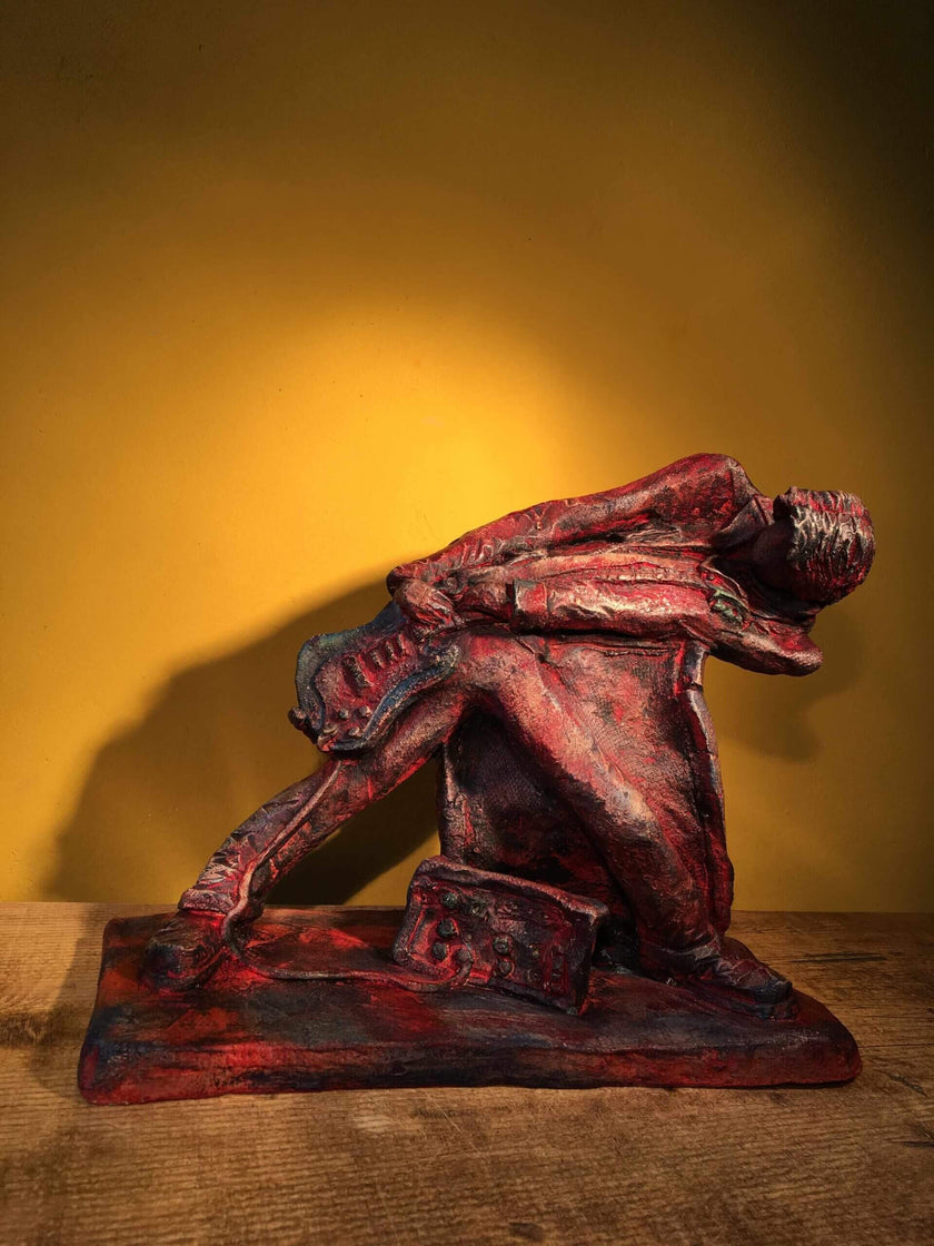 Ceramic sculpture of a rock guitarist painted red