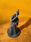 Ceramic sculpture of a kneeling guitarist painted blue.