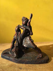 Ceramic sculpture of a singer and guitarist painted red.