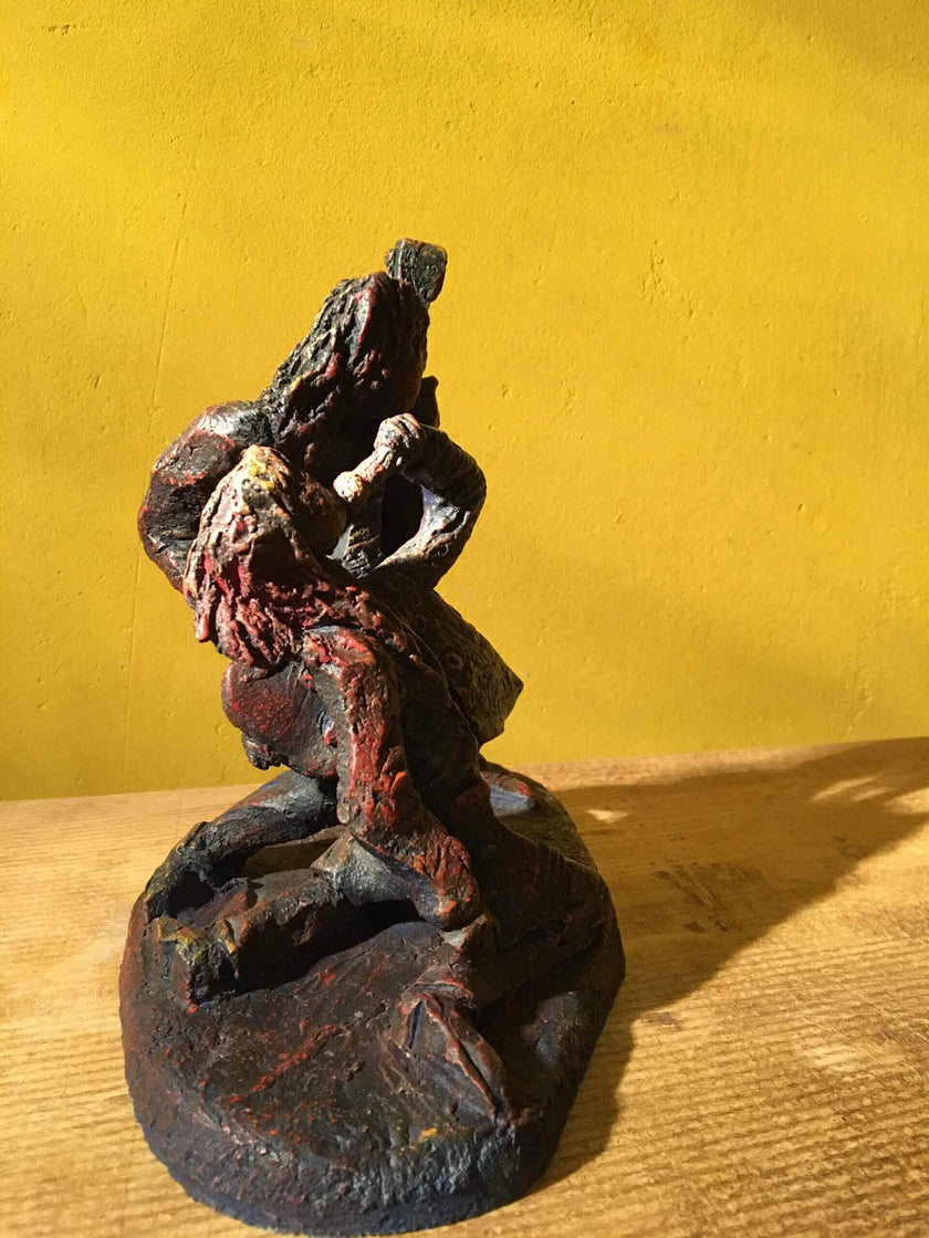 Ceramic sculpture of a singer and guitarist painted red.