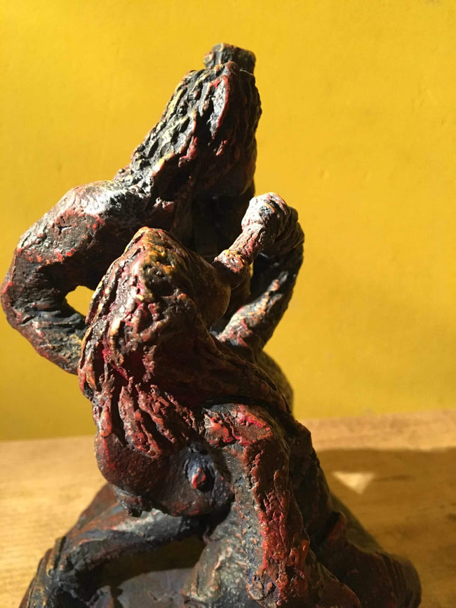 Ceramic sculpture of a singer and guitarist painted red.