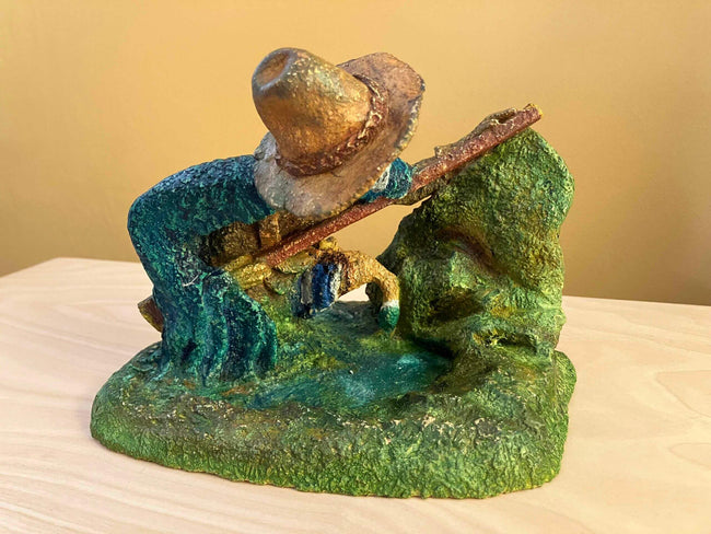 Ceramic sculpture of a Pilgrim Father hunter pointing a gun.