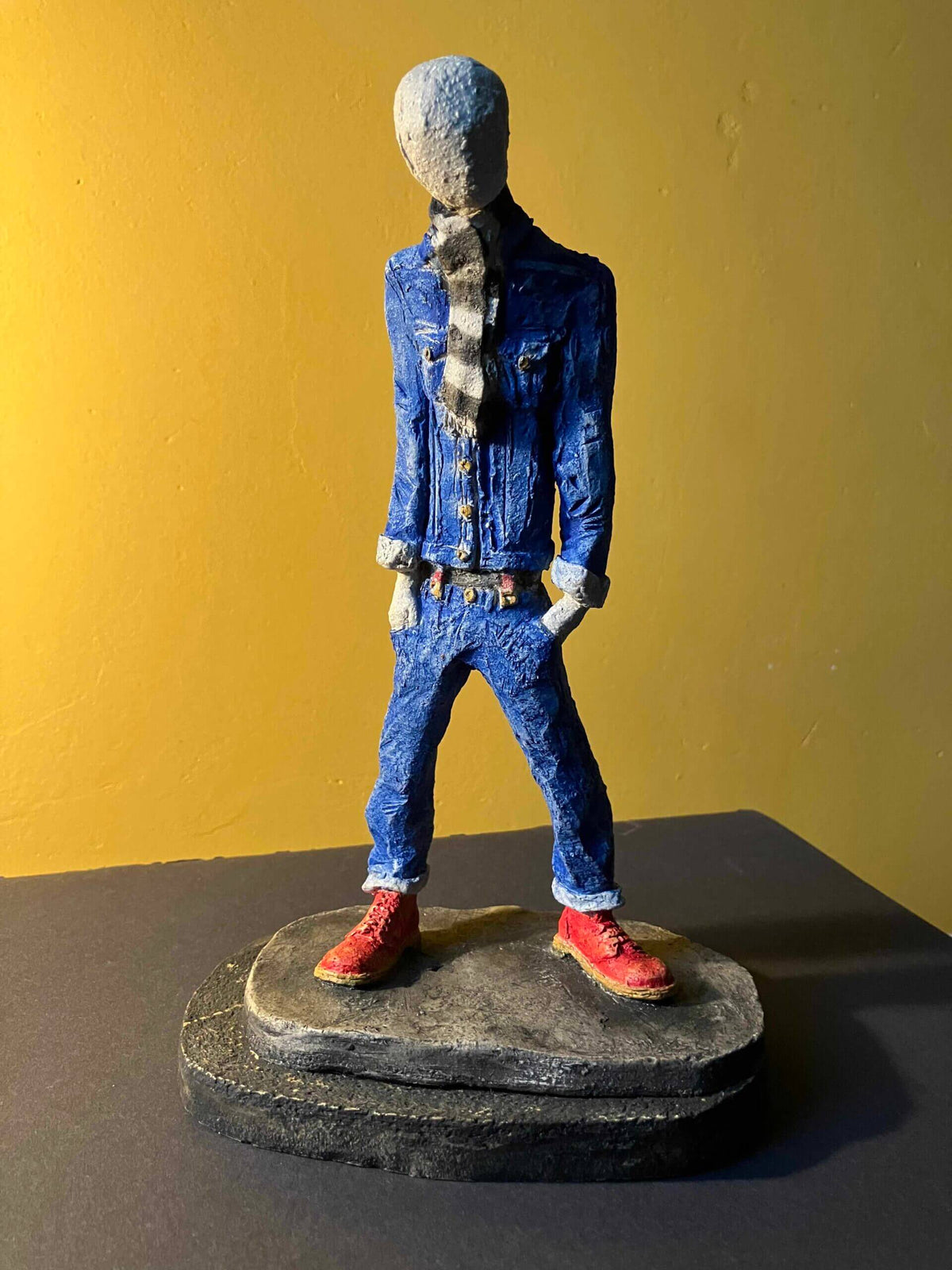 Ceramic sculpture of a skinhead in a black-and-white scarf