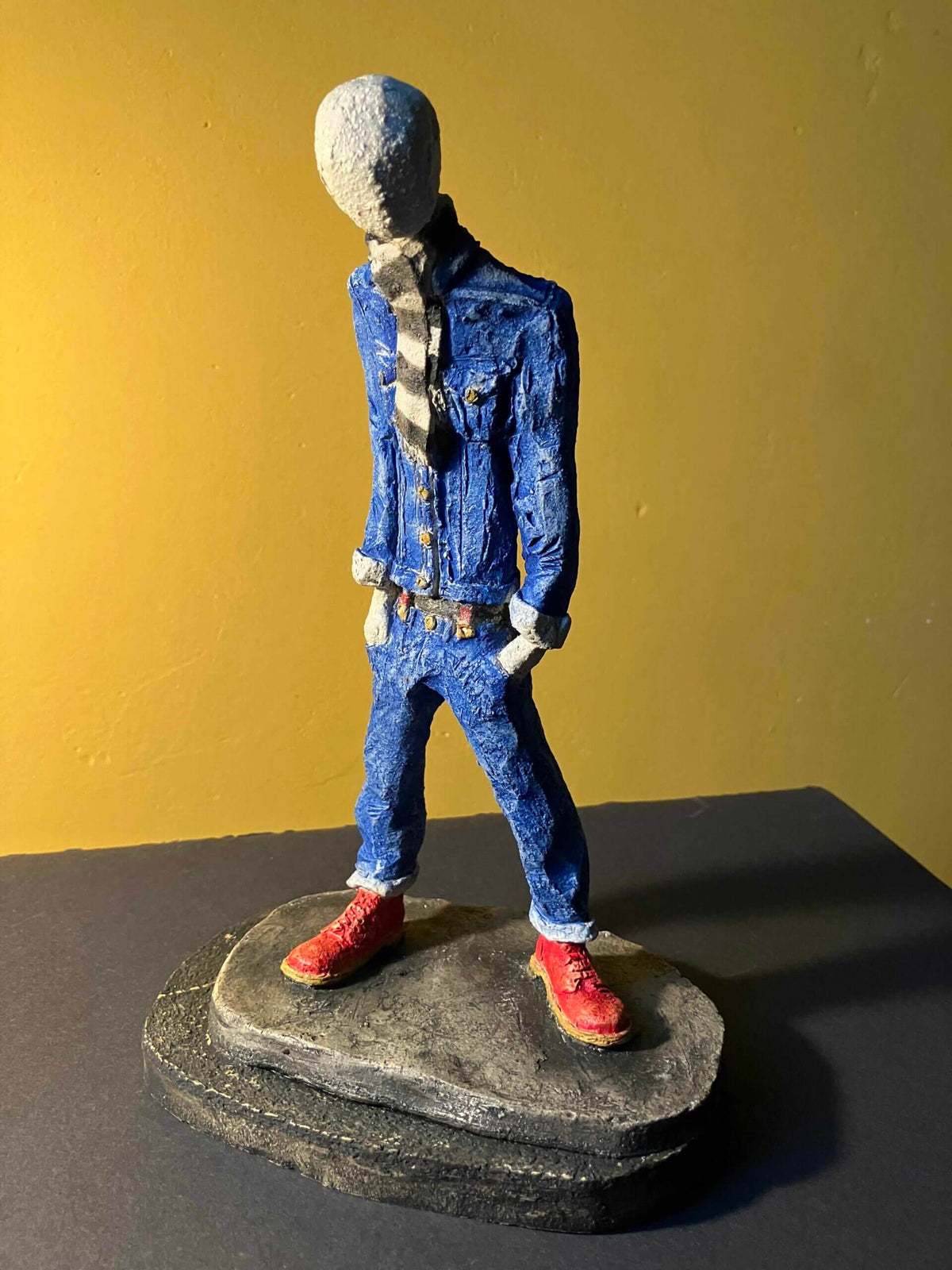 Ceramic sculpture of a skinhead in a black-and-white scarf