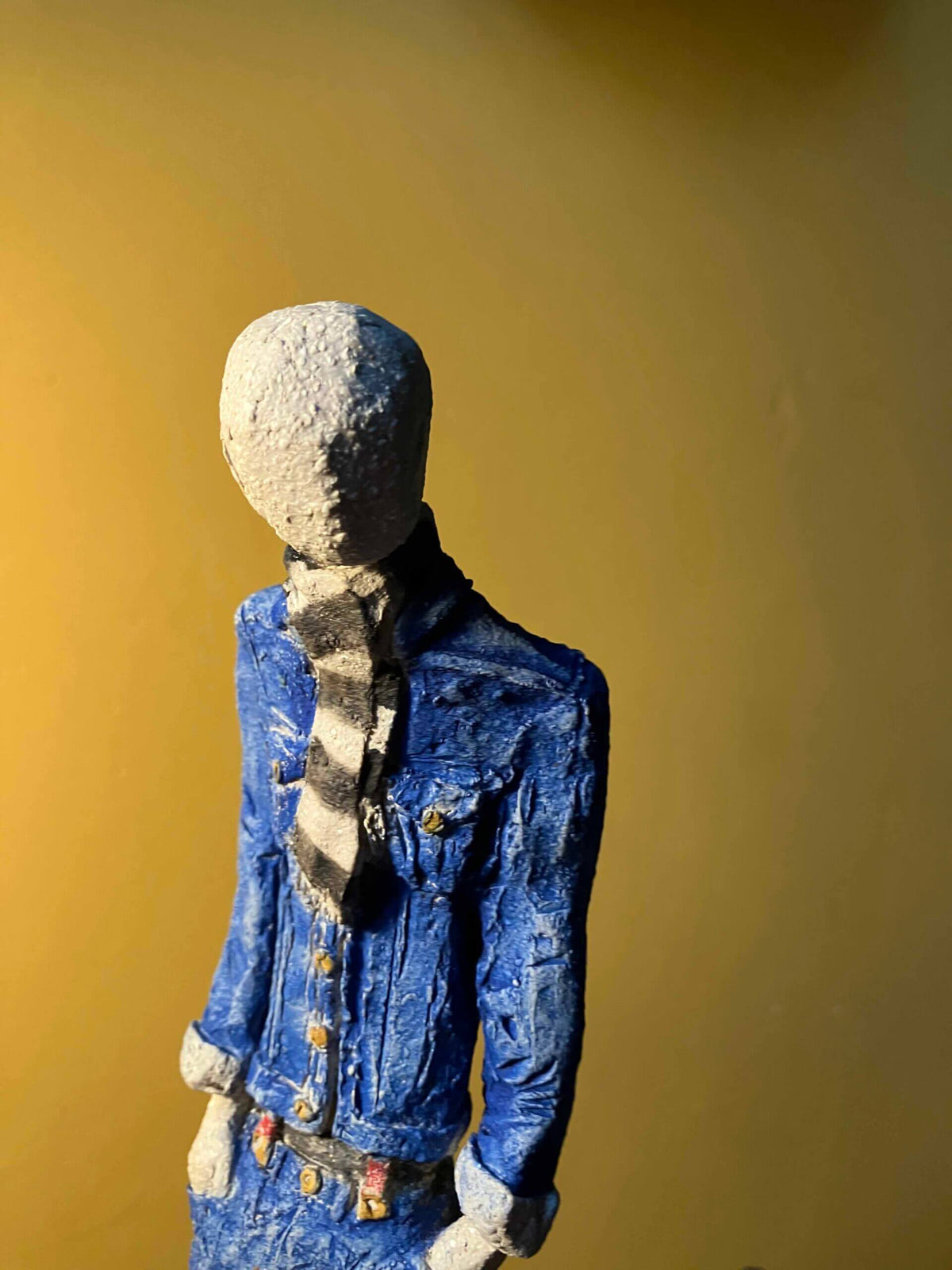 Ceramic sculpture of a skinhead in a black-and-white scarf