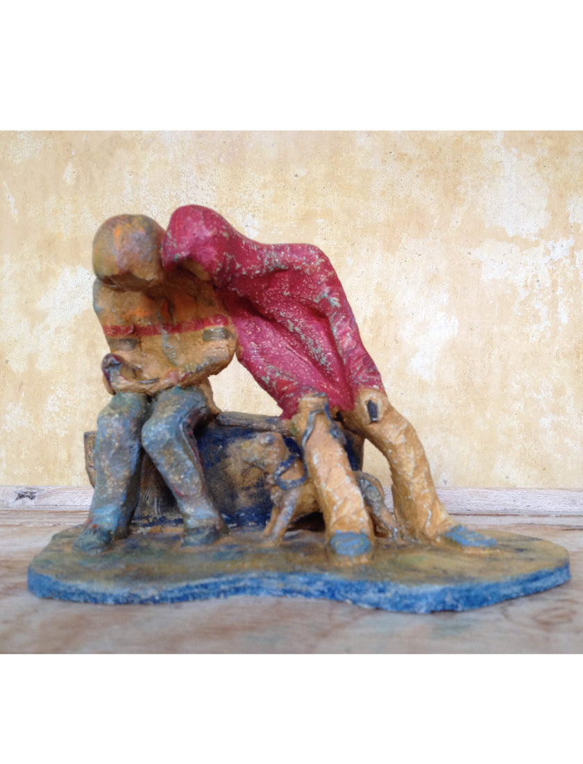 eramic sculpture of two figures sitting in hoodies looking at mobile phones with a dog at their feet.
