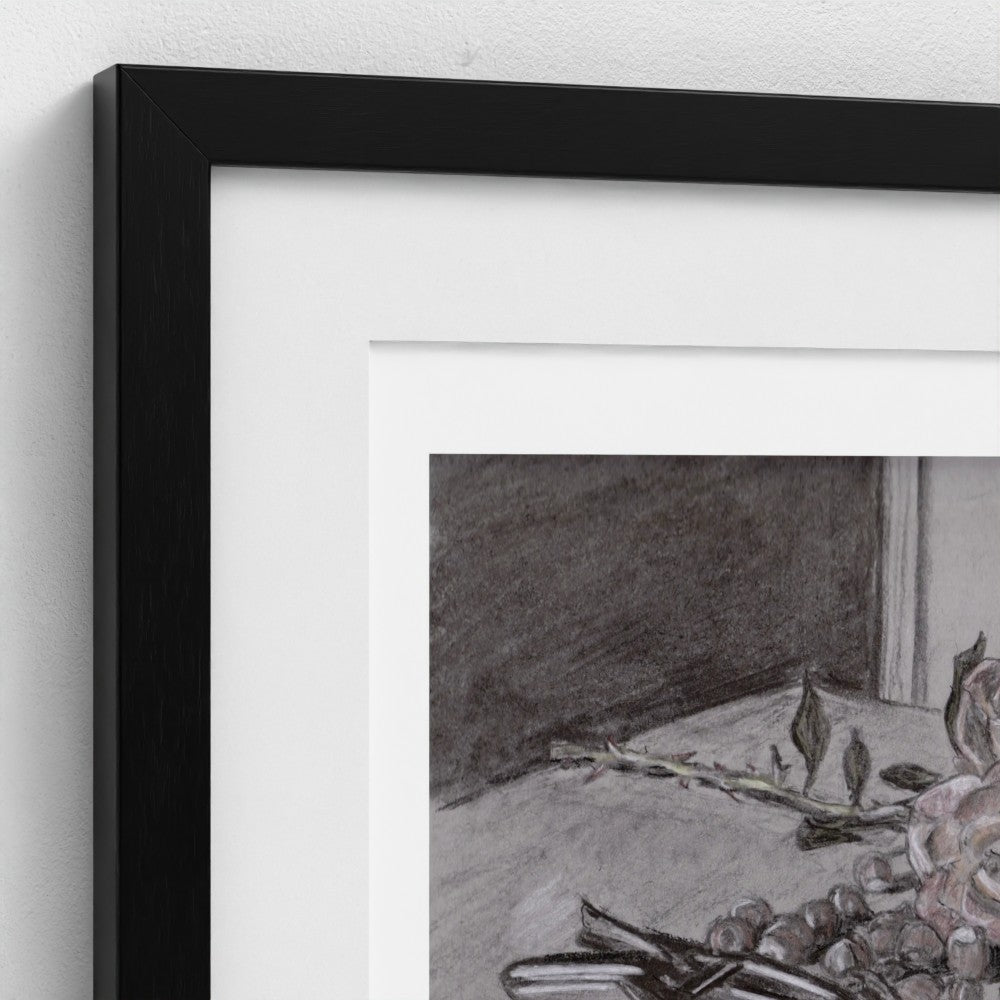 Close-up of a framed wall art print with a black frame, white mat, and a monochrome still-life drawing showing fruit and branches.