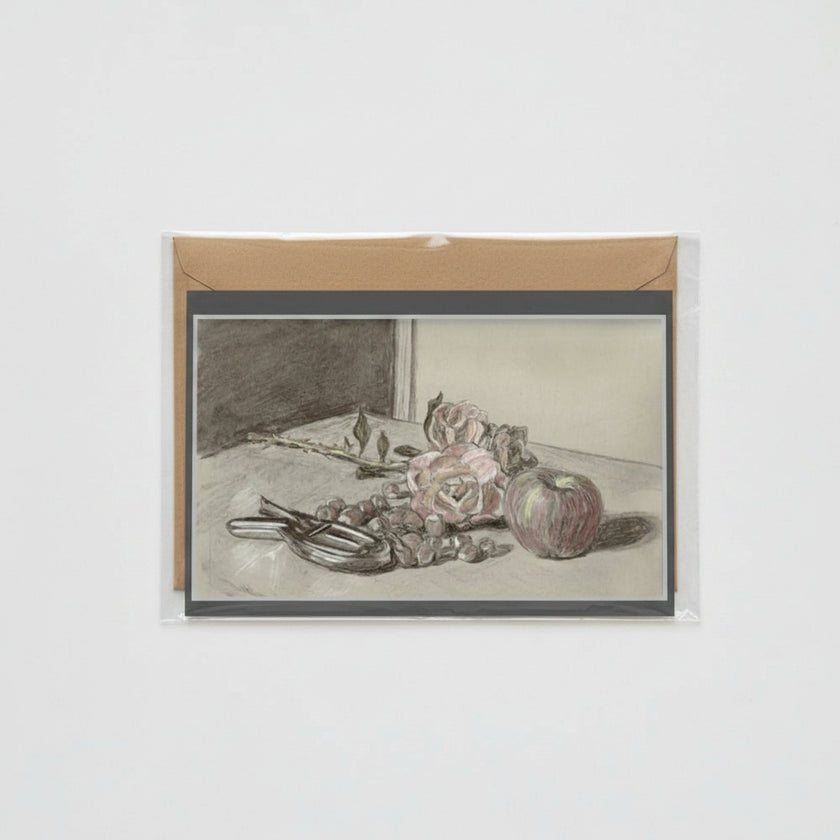 A card featuring a monochrome still life sketch of flowers, fruit, and a pair of nutcrackers, mounted on a brown kraft envelope against a light gray background.