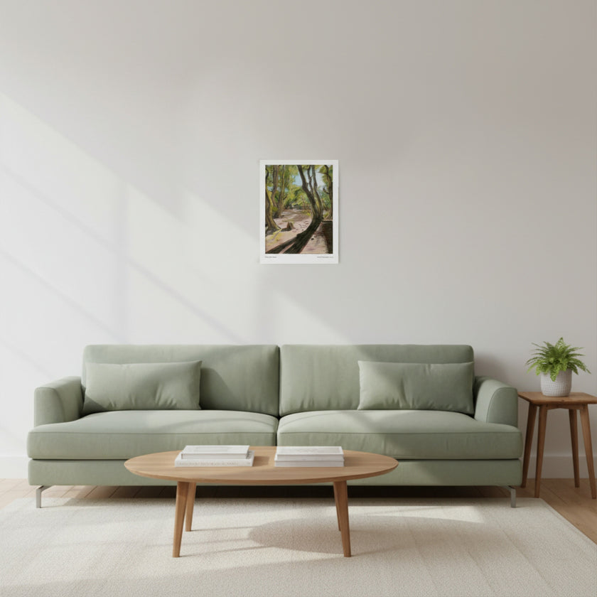 a landscape art print on a white wall above a green sofa and wood coffee table