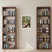 A landscape art print on a cream wall between two bookcases