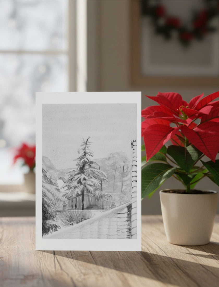Snowy Fir Tree Greetings card on a table with a poinsettia