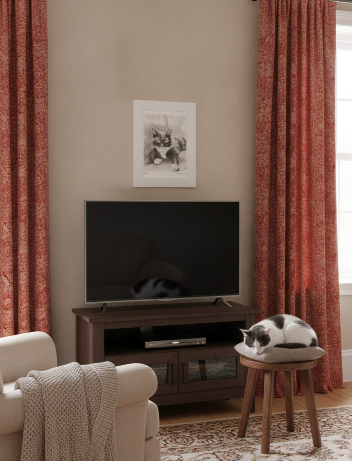 Edith the cat mounted art print on the wall above a television next to an armchair with a cat asleep on a stool