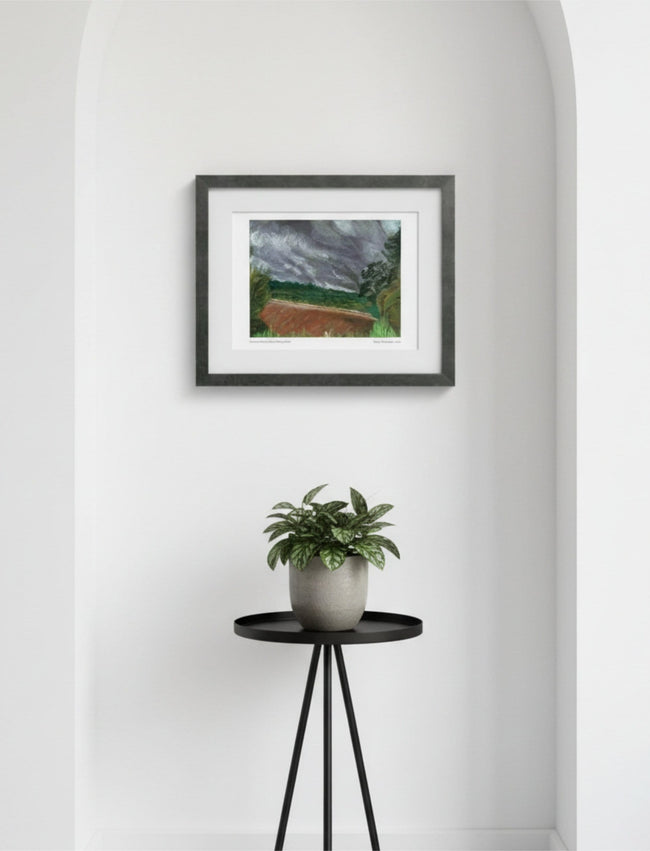 Summer Storm Near Witley Court Framed Art Print in an alcove above a small table with a potted plant on