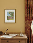 the view from St Mary's Kempley Framed Art Print above a desk with red curtains