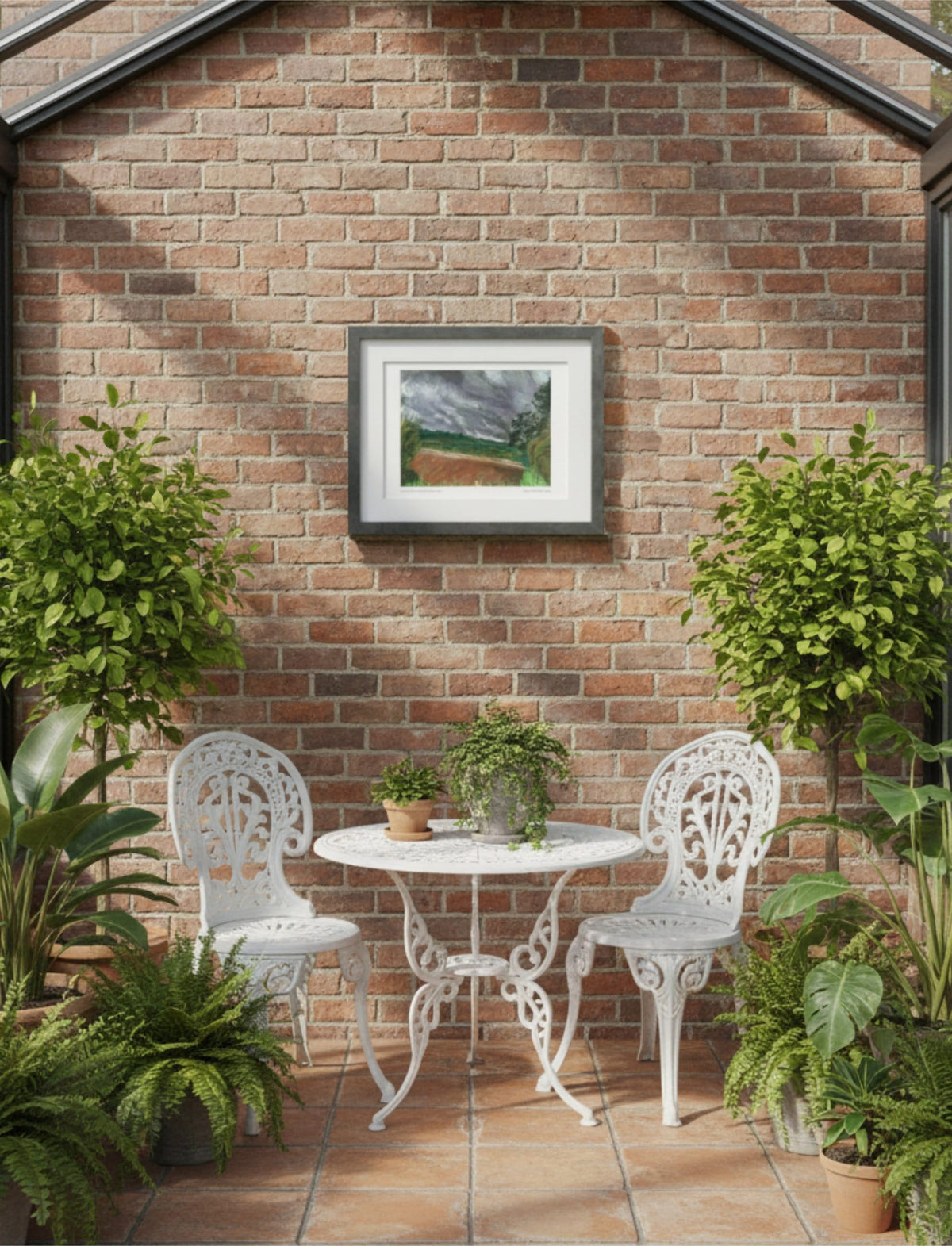 Summer Storm Near Witley Court Framed Art Print on a brick wall above white iron garden furniture with plants