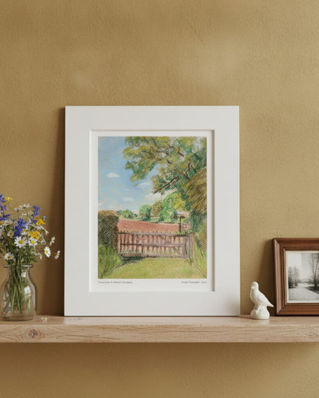 The View from St Mary's Kempley Mounted Art Print on a shelf with vase of flowers, bird ornament and photo in frame