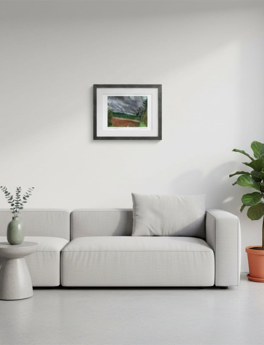 Summer Storm Near Witley Court Framed Art Print above a grey sofa with plants