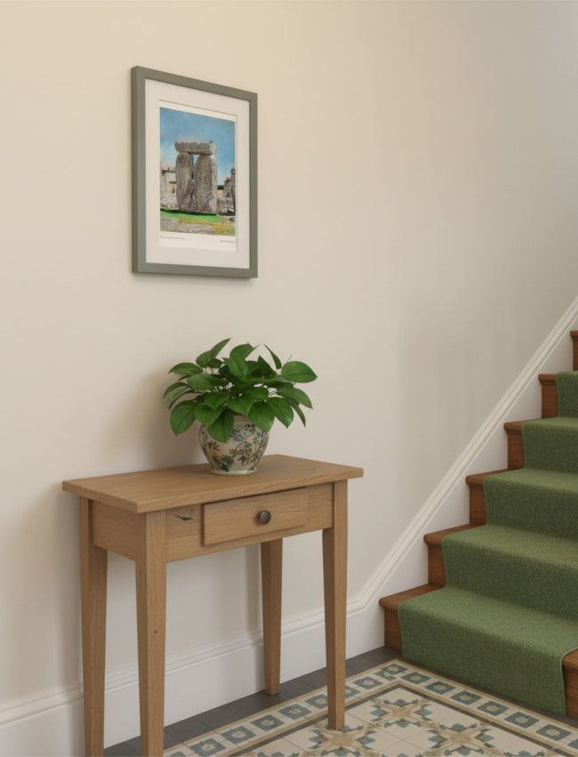 Sunny Summer at Stonehenge Framed Art Print in a hallway above a table with a potted plant