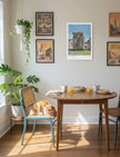 Sunny Summer at Stonehenge Art Print next to travel posters above a breakfast table with a cat on one chair