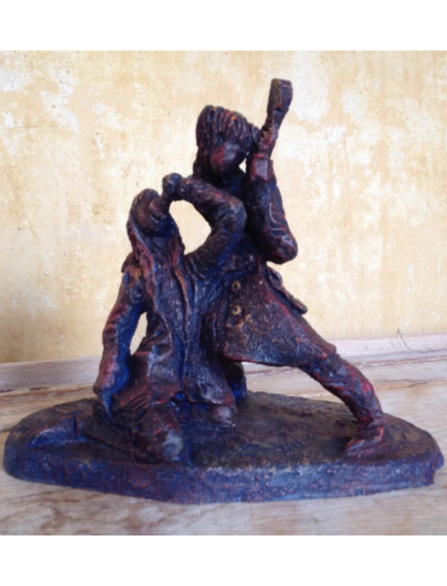 Ceramic sculpture of a singer and guitarist painted red.