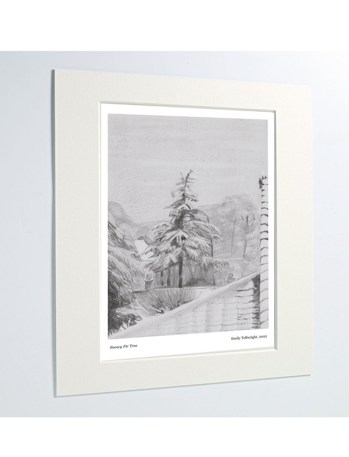 A matted art print featuring a pencil drawing of a fir tree in snow displayed against a light gray background.