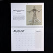 A single-page calendar spread showing August, with a black-and-white sketch of a dancer on the top page and a calendar grid on the bottom page, photographed against a black background.