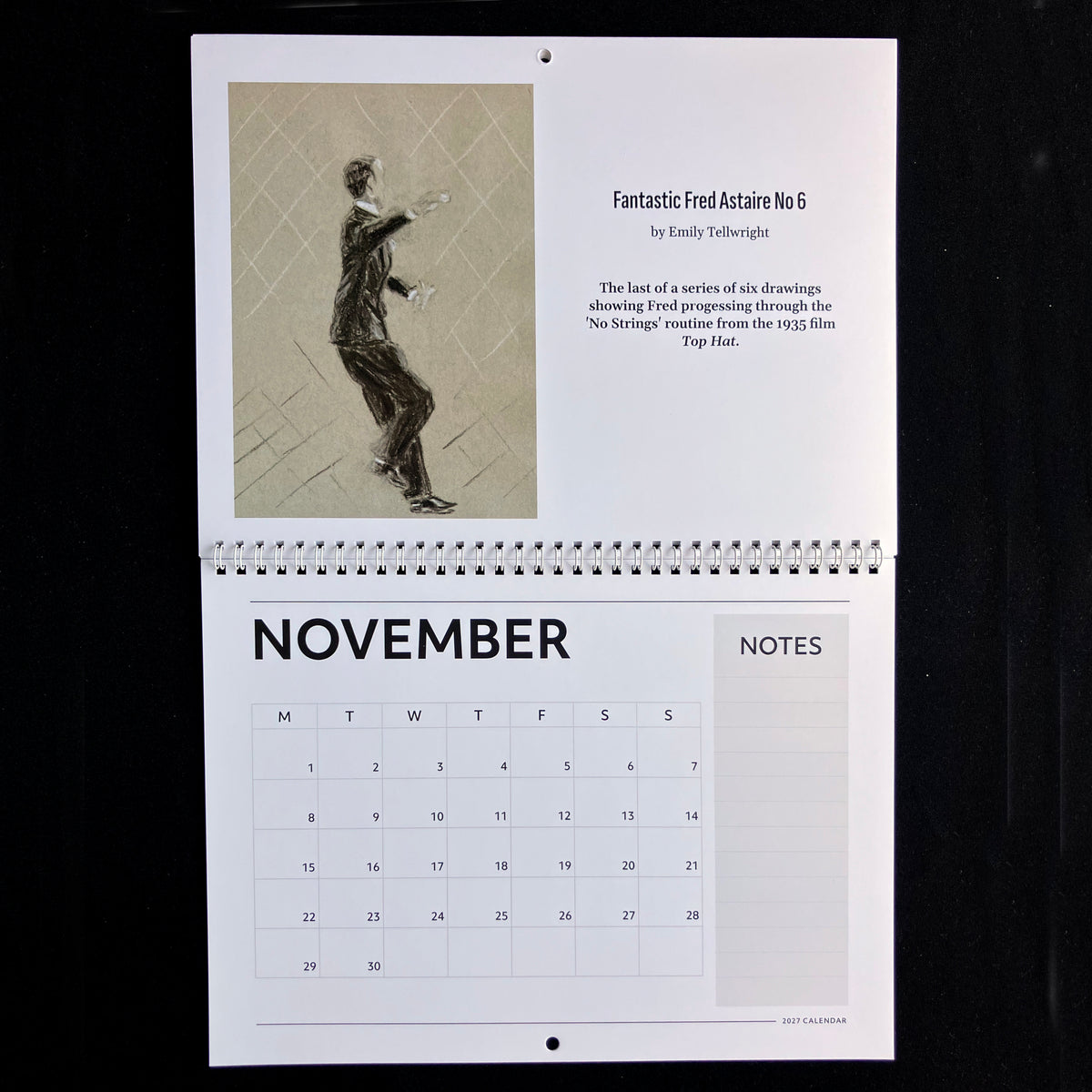 A spiral-bound November calendar page laid flat against a black background. The top section features an art print titled 'Fantastic Fred Actaire No 6' with a monochrome figure drawing and descriptive text.
