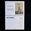 A single-page vintage art calendar or booklet page shown against a black background. The page has a spiral binder across the middle and includes printed text, a notes section, and a calendar grid for October.