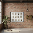 A framed black-and-white collage of vintage dance or gymnastic poses hangs on a red brick wall in a styled room with a potted plant, hanging light fixture, shelf with plants, and a cat resting on a rug.
