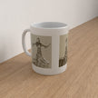 A white ceramic mug with sepia-toned vintage fashion illustrations, sitting on a light wood tabletop against a plain off-white wall.