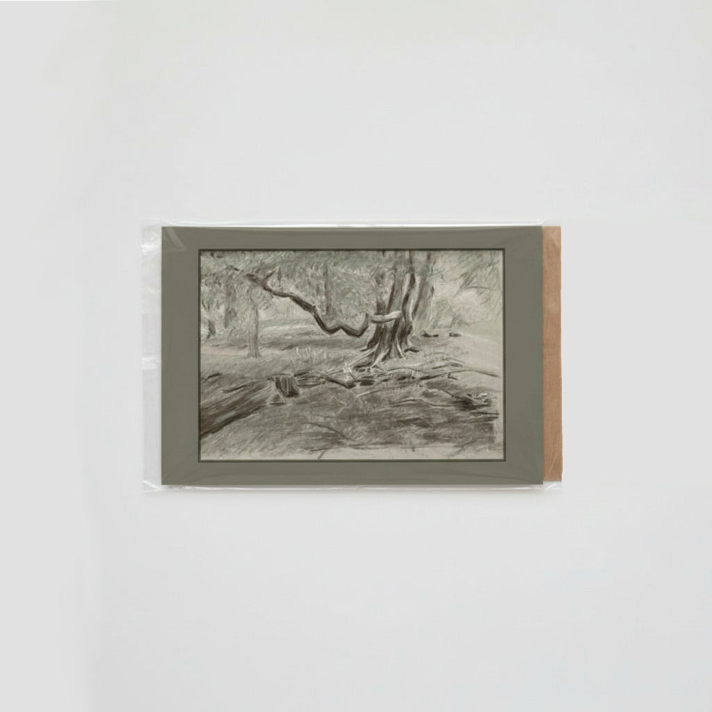 A monochrome landscape sketch of trees and forest floor, mounted on a light gray backing with a brown paper edge, photographed against a plain white background.